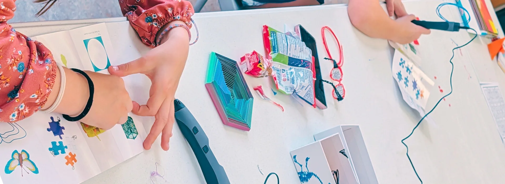 two sets of hands using 3D pens
