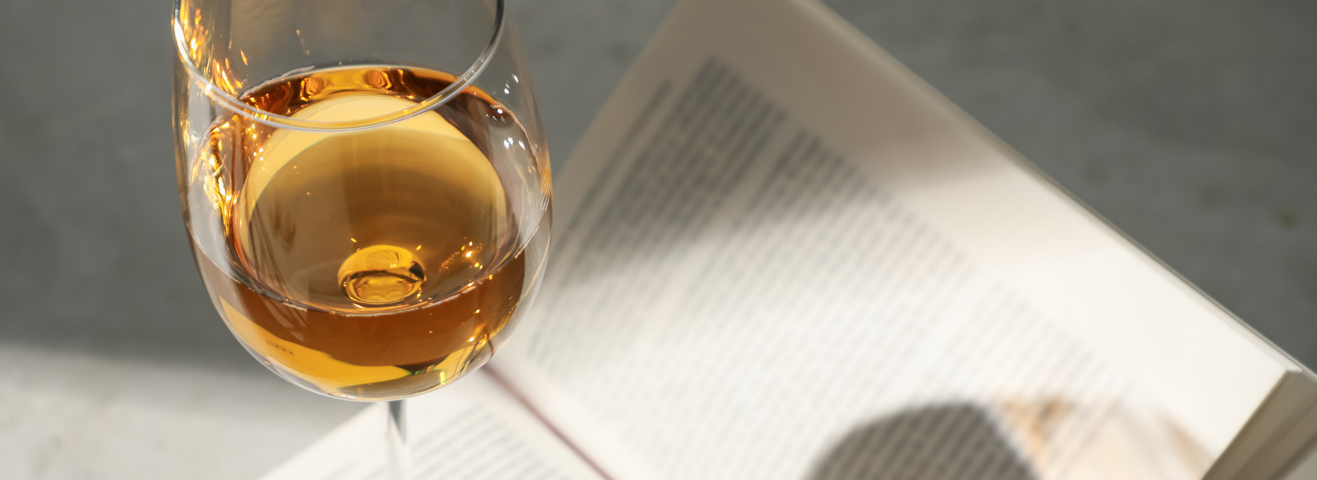 Glass of white wine sitting on top of a book.
