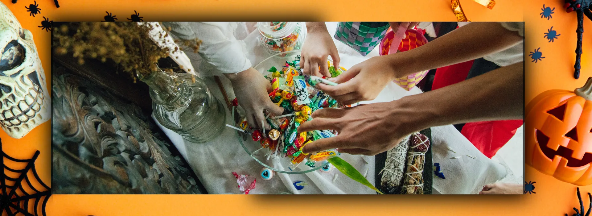Children's hands reaching into bowl of candy.
